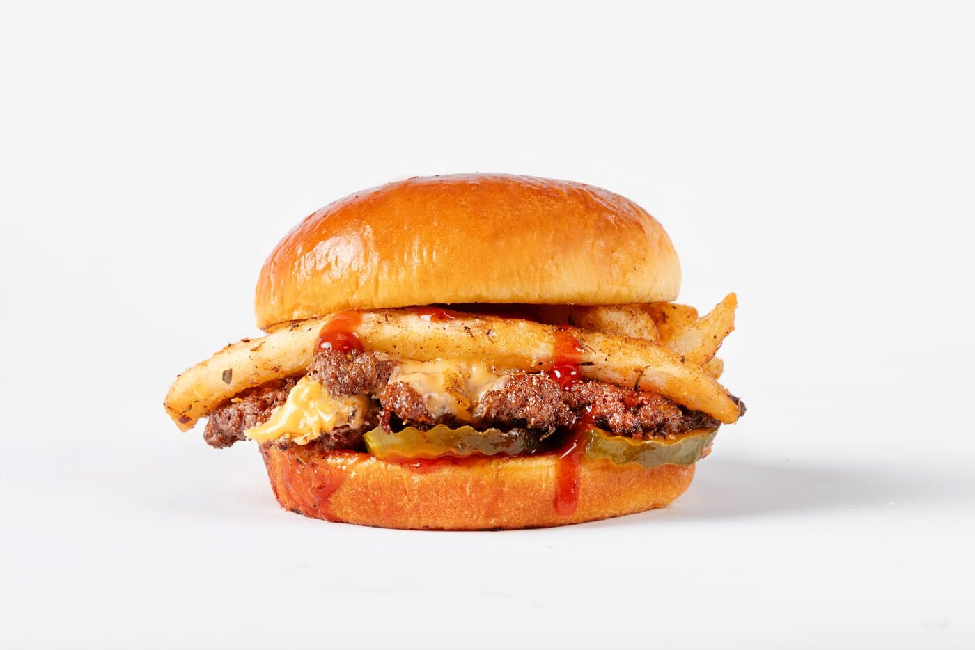 Jerk Smash burger with fries tucked in, Jerk BBQ Sauce, cheese and pickles